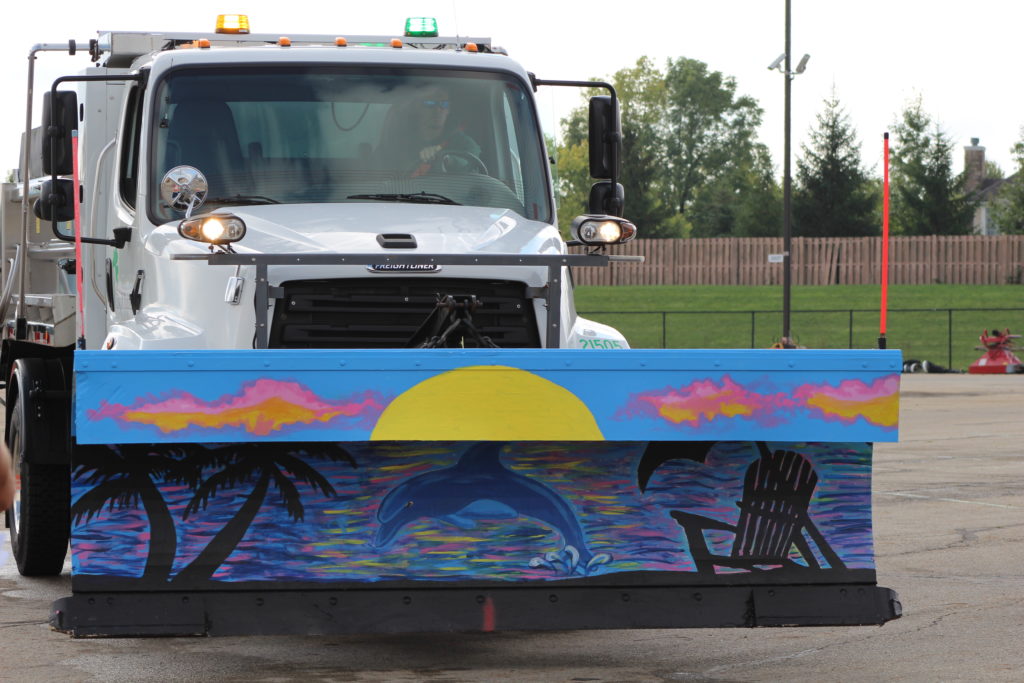 Photo of a snowplow with a tropical image painted on the plow blade