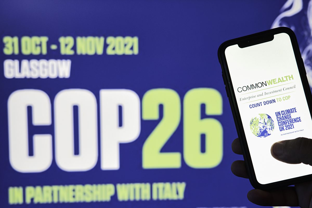 COP26 logo with hand holding phone