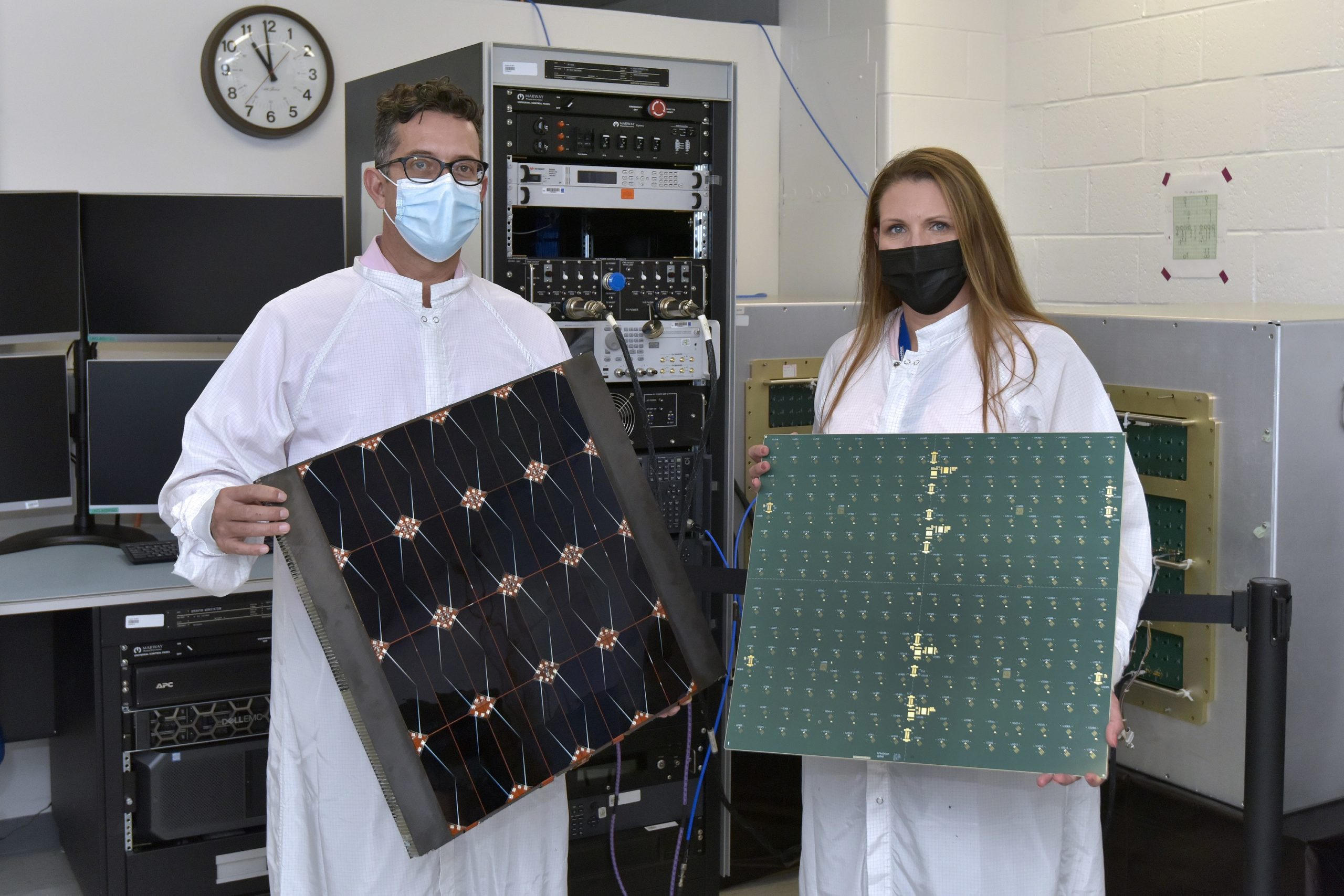 Male and female scientists holding solar panels