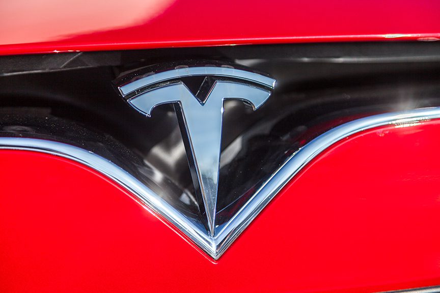 close up of Tesla logo red car