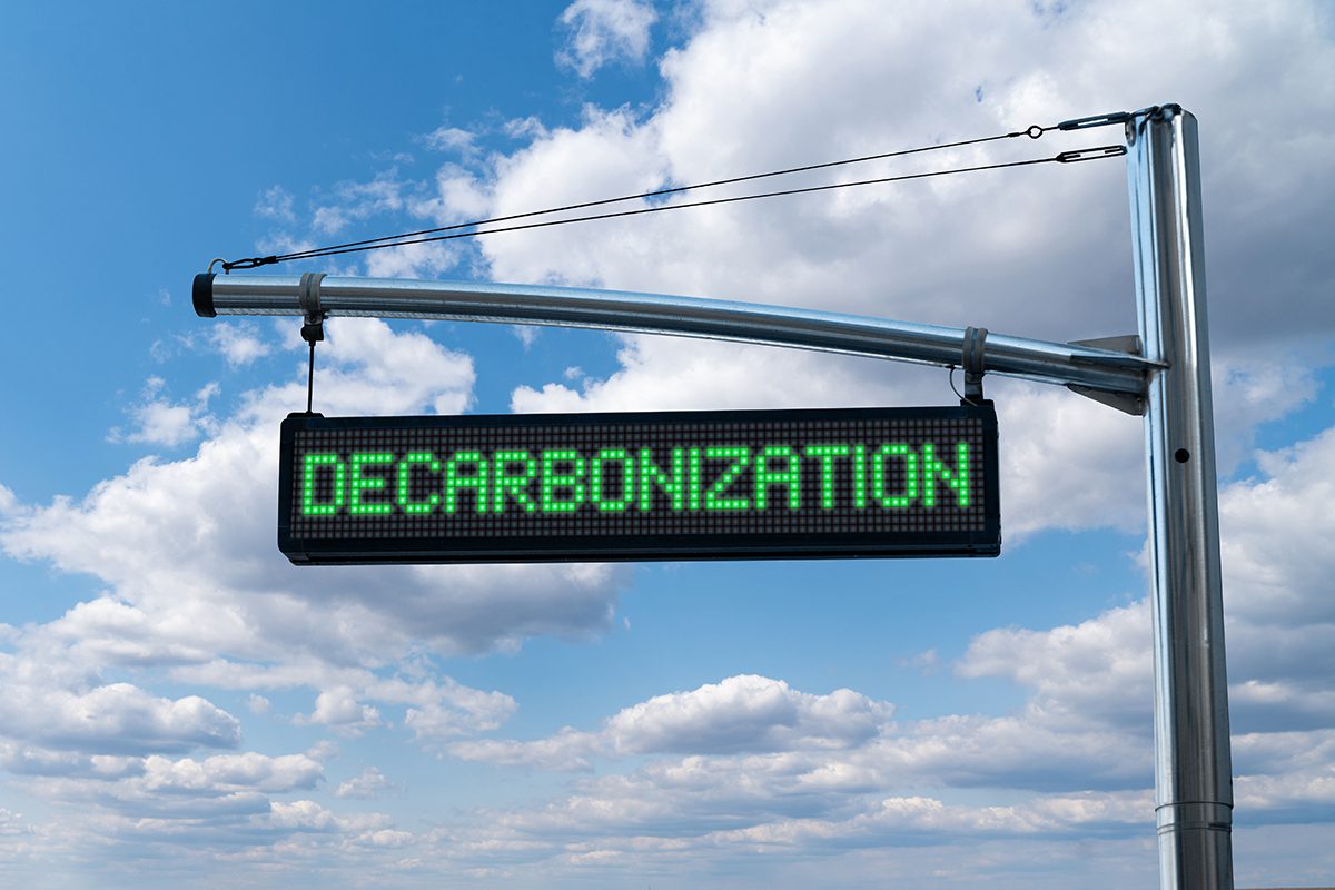 Road information board with text DECARBONIZATION on a background
