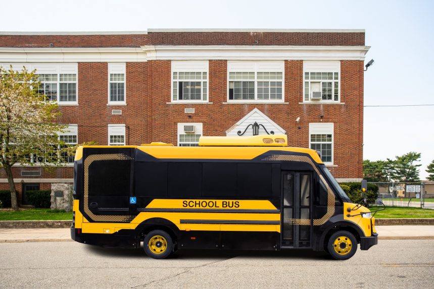 yellow electric school bus in front of school
