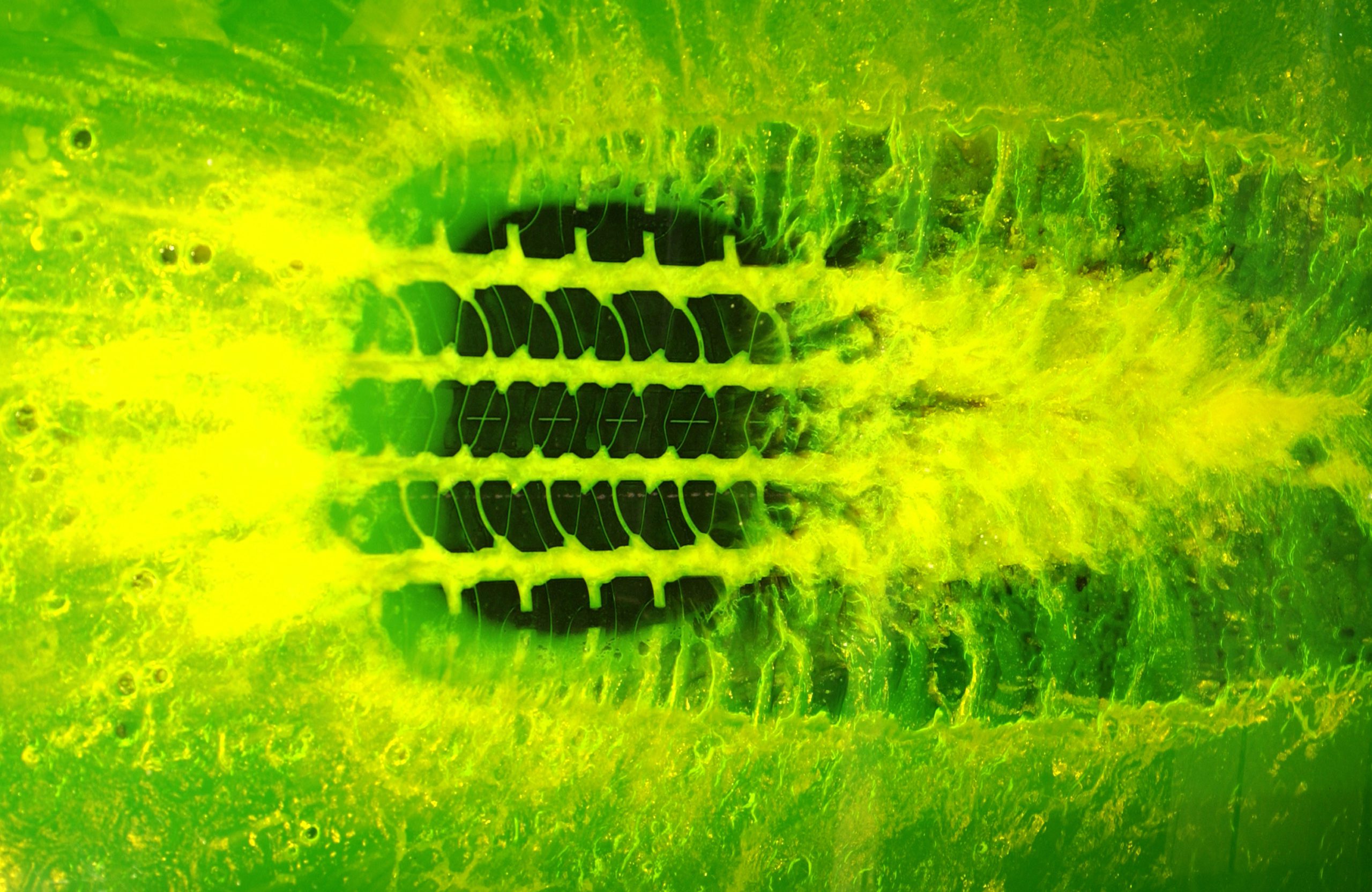 tire tread moving over a green and yellow liquid