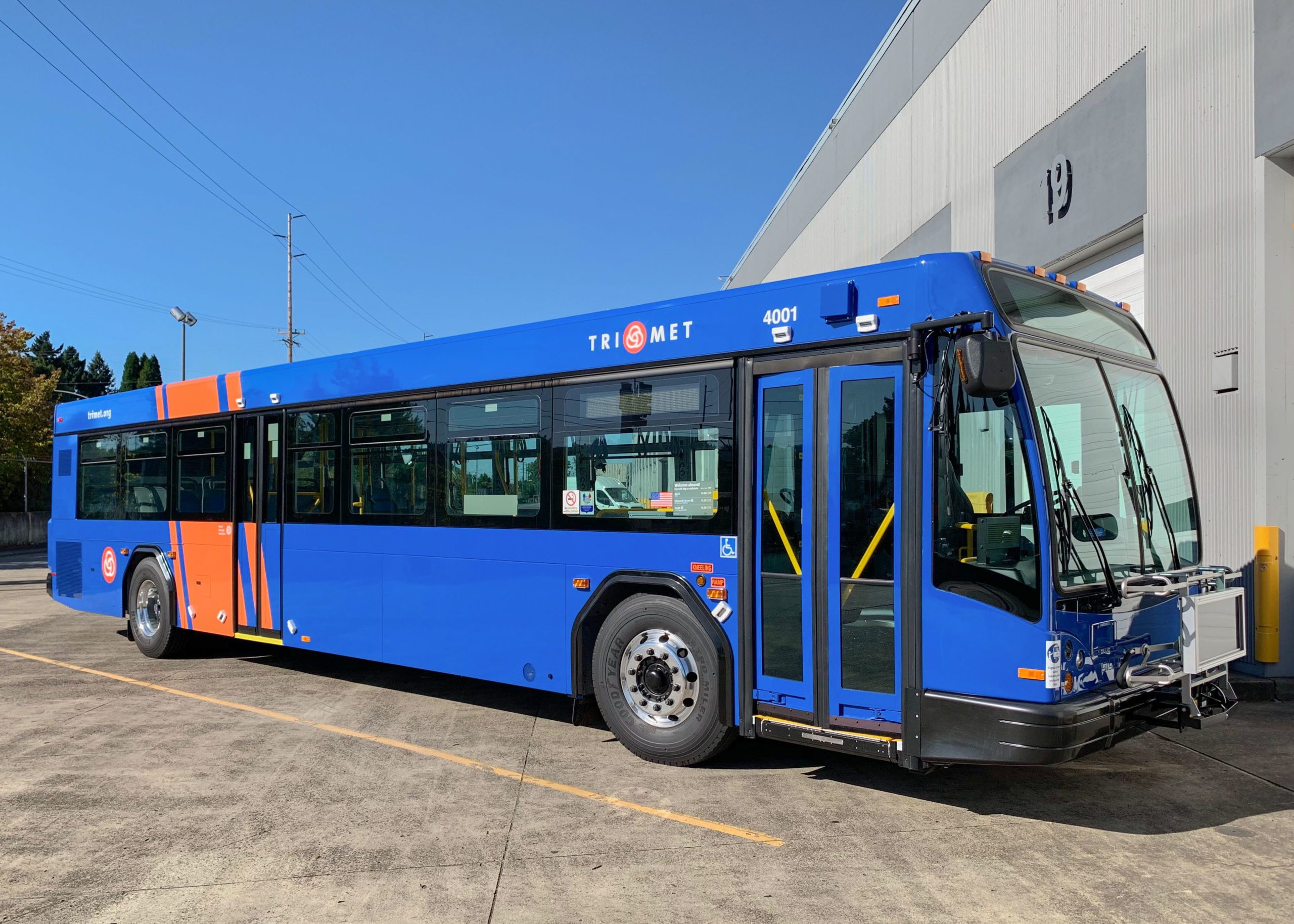 orange and blue battery electric transit bus parked