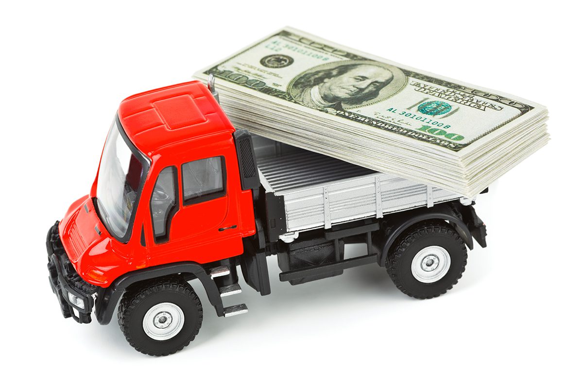 red toy truck with stack of money on trailer bed